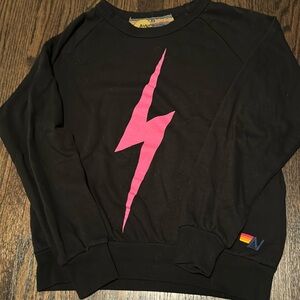 Black crewneck with neon pink bolt